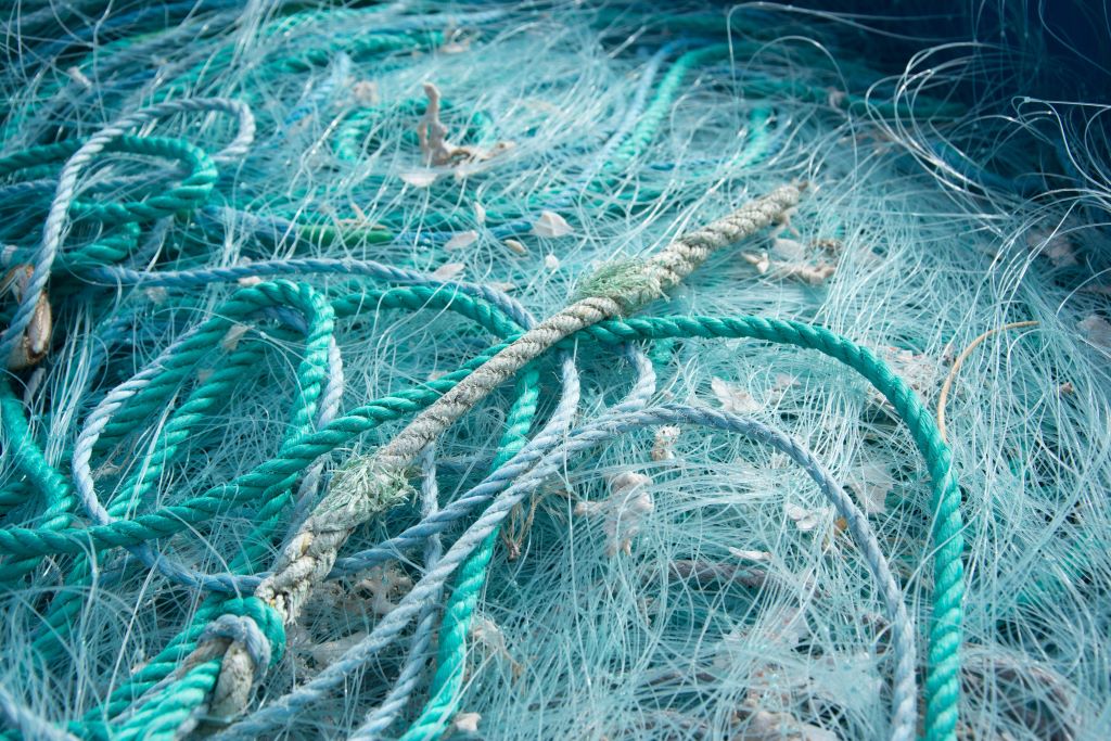 Primer plano cuerdas azules redes pesca entre si bajo luz sol